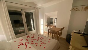 A hotel room with a bed, a desk, and a television. - CHAMBRE GRAND CONFORT COQUET with PRIVATE JACUZZI (Martignargues)
