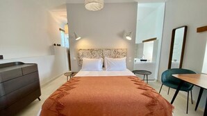 Une chambre moderne avec un grand lit, une commode, un bureau et une chaise.