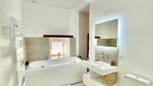 Une salle de bain moderne avec une baignoire, des toilettes et un lavabo.
