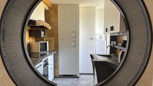 Una cocina con microondas, estufa y armarios.