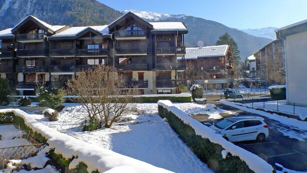A multi-story hotel with balconies and a mountainous backdrop. - Charming Apartment in Samoëns with Balcony and Parking, Sleeps 6 (Samoëns)