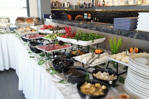 A buffet with various food items and a bar area with bottles. - Turkay Hotel (Konyaalti)
