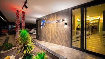A modern hotel exterior with a prominent sign reading "TURKAYHOTEL".