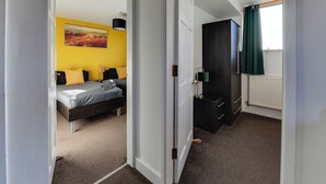 A bedroom with a bed, a painting on the wall, and a window with curtains. - 3 Bedroom Home. Home Working. Free Parking. Garden. Wigan (Wigan)