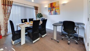A modern dining area with a table, chairs, and a potted plant. - 3 Bedroom Home. Home Working. Free Parking. Garden. Wigan (Wigan)