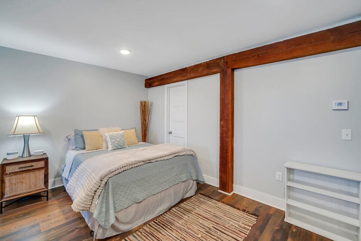A bedroom with a bed, bedside table, lamp, and a radiator.