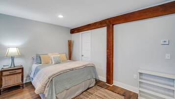 A bedroom with a bed, bedside table, lamp, and a radiator.