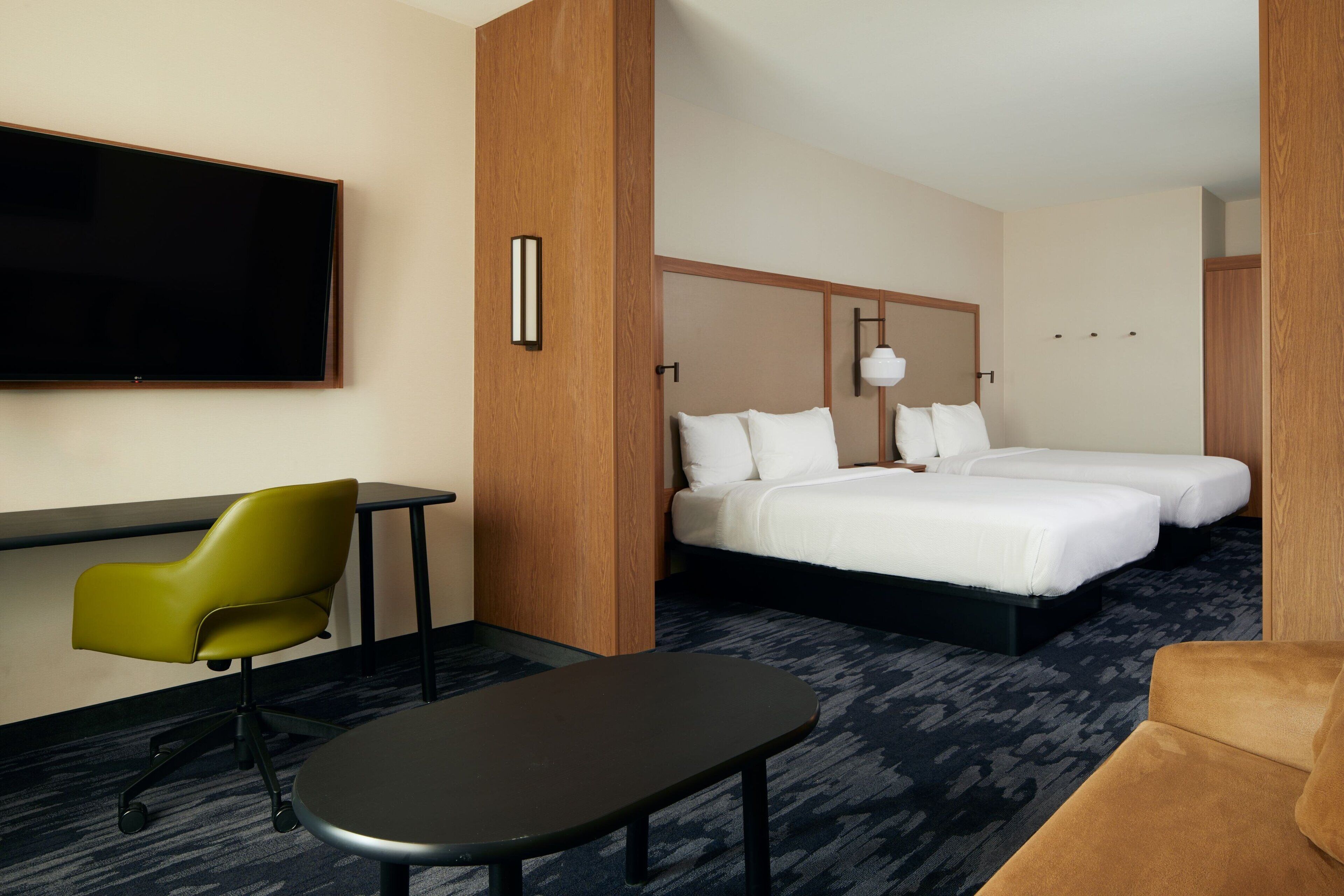 Een hotelkamer met een bed, bureau, stoel en televisie.