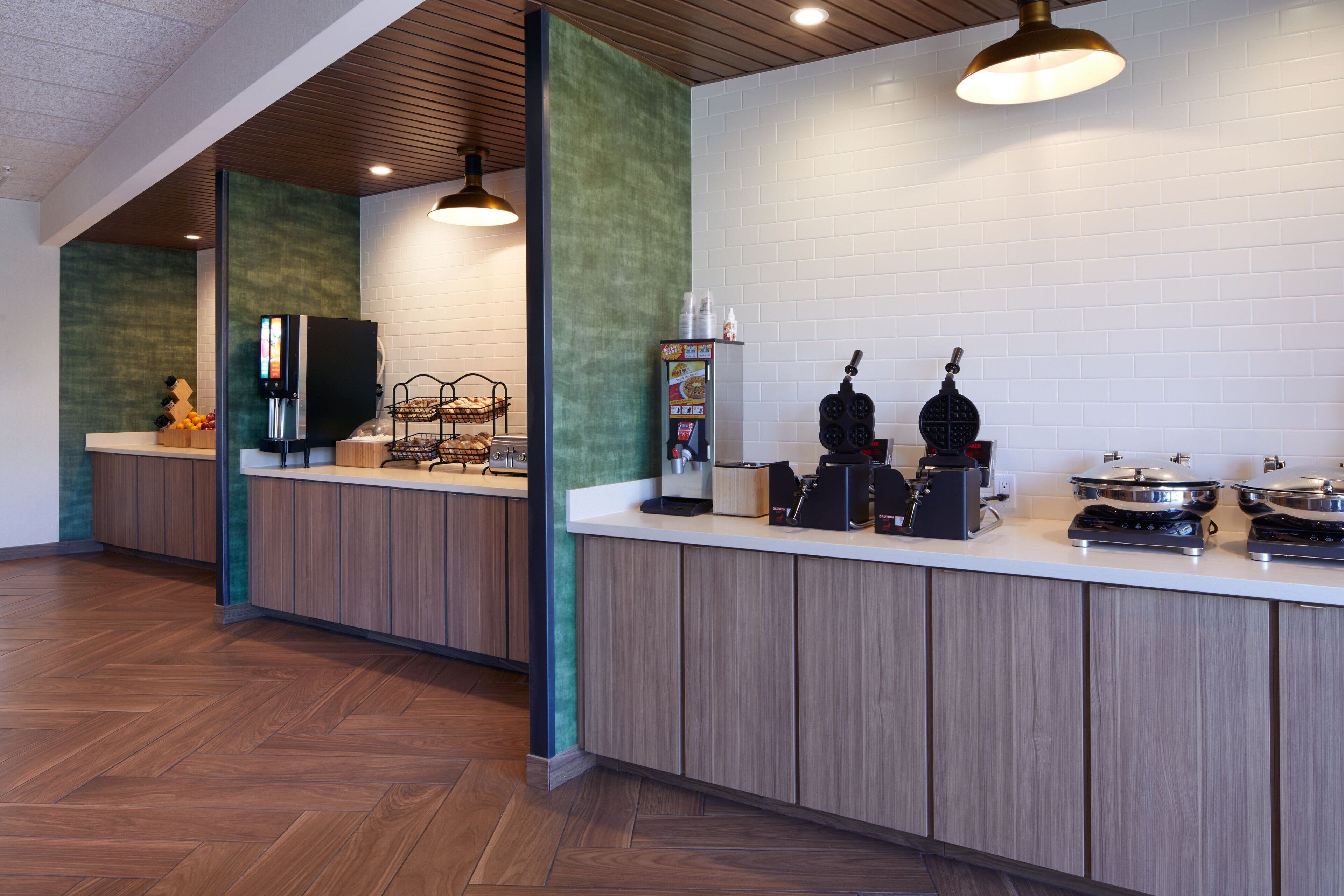 A modern kitchen with wooden cabinets, a white countertop, and a coffee machine.