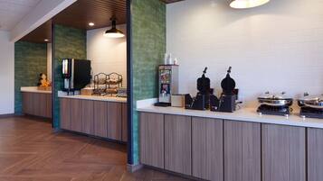 A modern kitchen with wooden cabinets, a white countertop, and a coffee machine.