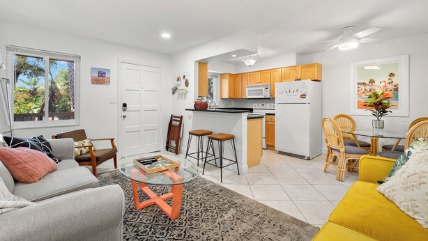 A modern apartment with a kitchen, dining area, and living room. - Waves by Distinctive Beach Rentals (St. Pete Beach)