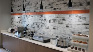 A breakfast bar with a coffee machine, toaster, and various pastries. - La Quinta Inn & Suites by Wyndham Bardstown (Bardstown)