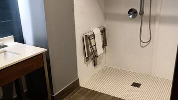 Un baño con ducha, toallero y lavabo.