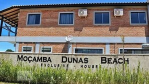 A two-story building with a sign that reads "Mocamba Dunas Beach Exclusive House." - Pousada Moçamba Dunas (Florianópolis)