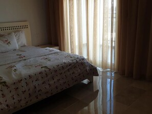 Une chambre à coucher avec un lit, des rideaux et une vue sur l’extérieur.