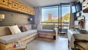 Een moderne woonkamer met een bank, een eettafel en een televisie.