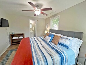 A bedroom with a bed, a ceiling fan, a window, and a TV on the wall. - 4BR Getaway | King Bed | Prime Uptown-SouthEnd (Charlotte)
