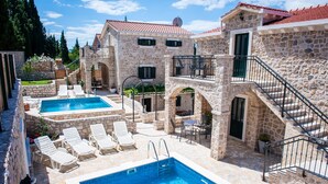 A stone building with a swimming pool, outdoor seating, and a staircase. - STONE HOUSES , COMPLETE PRIVACY , 7 BEDROOMS , 2 POOLS , IDEAL PLACE FOR HOLIDAY (kremena)