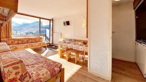 Una habitación acogedora con cama, una mesa de comedor y vistas a la montaña.
