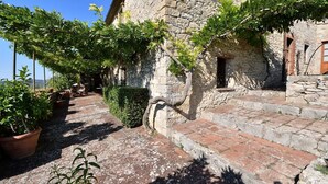 A stone building with a rustic staircase and potted plants.