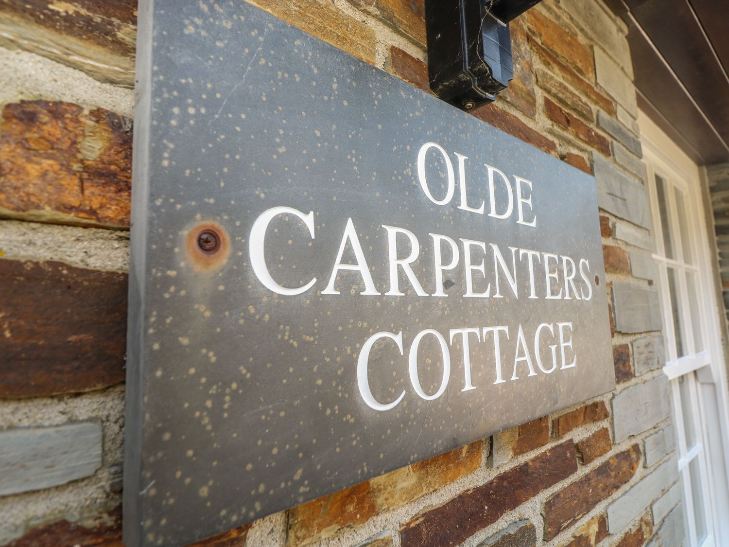 A sign for Olde Carpenters Cottage.