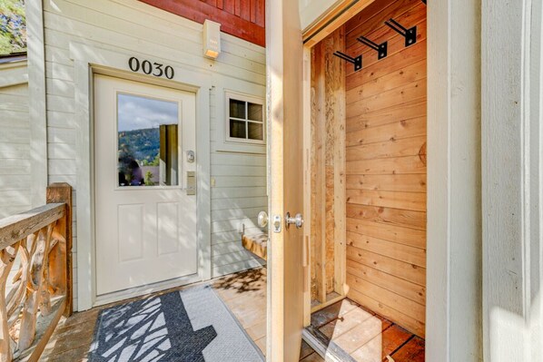 A wooden door with the number 0030, a white door with a window, and a wooden exterior wall.