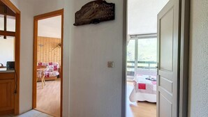 Ein Flur, der in einen Essbereich führt, mit einer Holztür und einem an der Wand befestigten Schild.