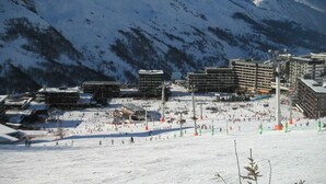 A ski resort with multiple buildings, ski lifts, and a snowy landscape with mountains in the background. - 100m from ski slopes, 7th floor, view mountain, balcony, tv, ski locker, 36m², Les Menuires (Les Menuires)
