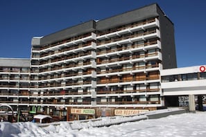 Hotel com vários andares, varandas, pizzaria Tex-Mex e bar-restaurante.