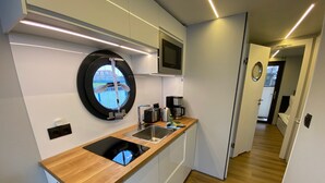 A modern kitchen with a sink, a microwave, and a coffee maker.