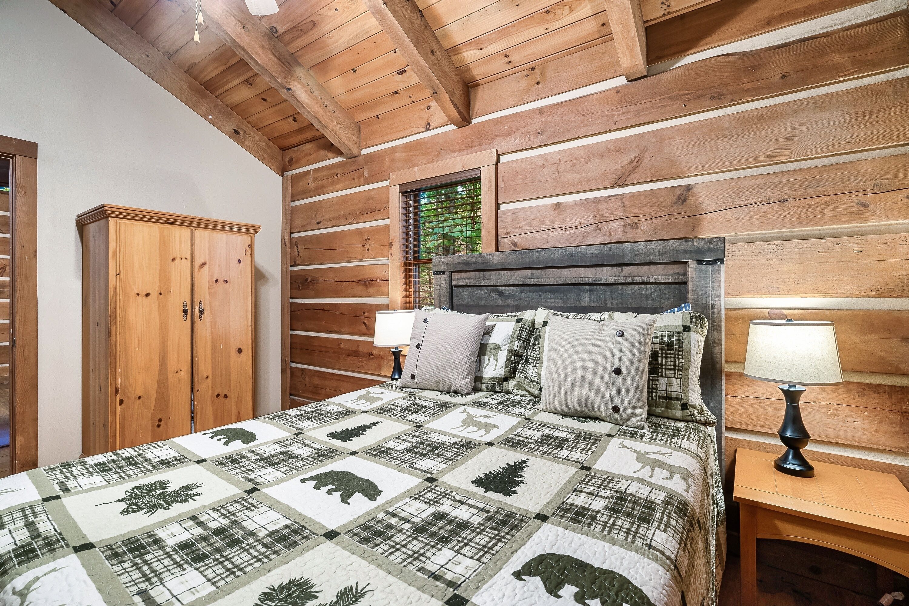 Een slaapkamer in chaletstijl met een bed, nachtkastjes en een kledingkast.