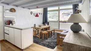 A cozy kitchen with a dining area, wooden furniture, and a view of the outdoors. - 200m from resort center, 12nd floor, balcony, tv, ski locker, 37m², Les Menuires (Les Menuires)