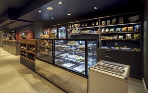 A bakery display with various baked goods and a selection of packaged snacks. - Ibis Budget Farroupilha (Farroupilha)