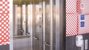 Een lift met een digitaal scherm, knoppen voor noodcontact en een handgreep.