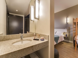 A bathroom with a granite countertop, a sink, a mirror, and a toilet. - Ibis Budget Farroupilha (Farroupilha)