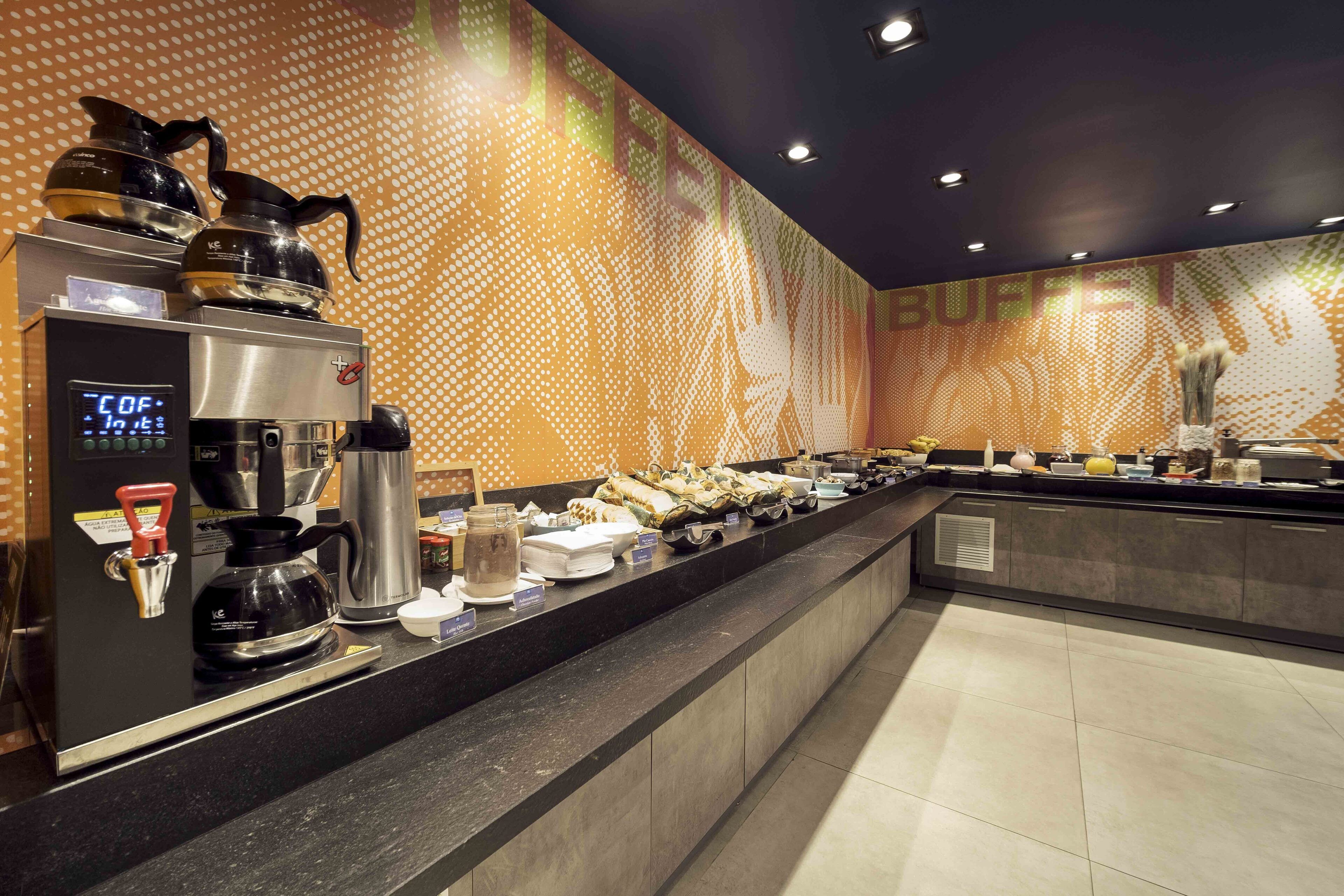 A buffet area with a coffee station, including a coffee maker and a digital clock displaying the time.