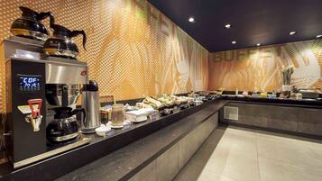 A buffet area with a coffee station, including a coffee maker and a digital clock displaying the time.