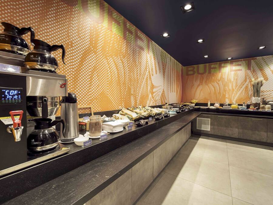 A buffet area with a coffee station, including a coffee maker and a digital clock displaying the time.