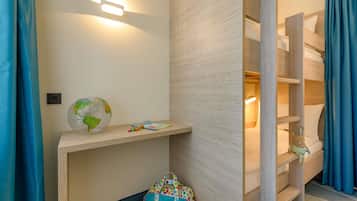 Una habitación con una cama litera, un globo terráqueo, una bolsa colorida y una repisa con una lámpara.