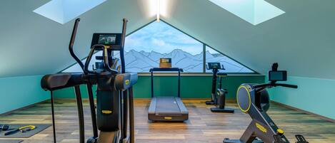 A gym with cardio equipment, a treadmill, and a rowing machine.