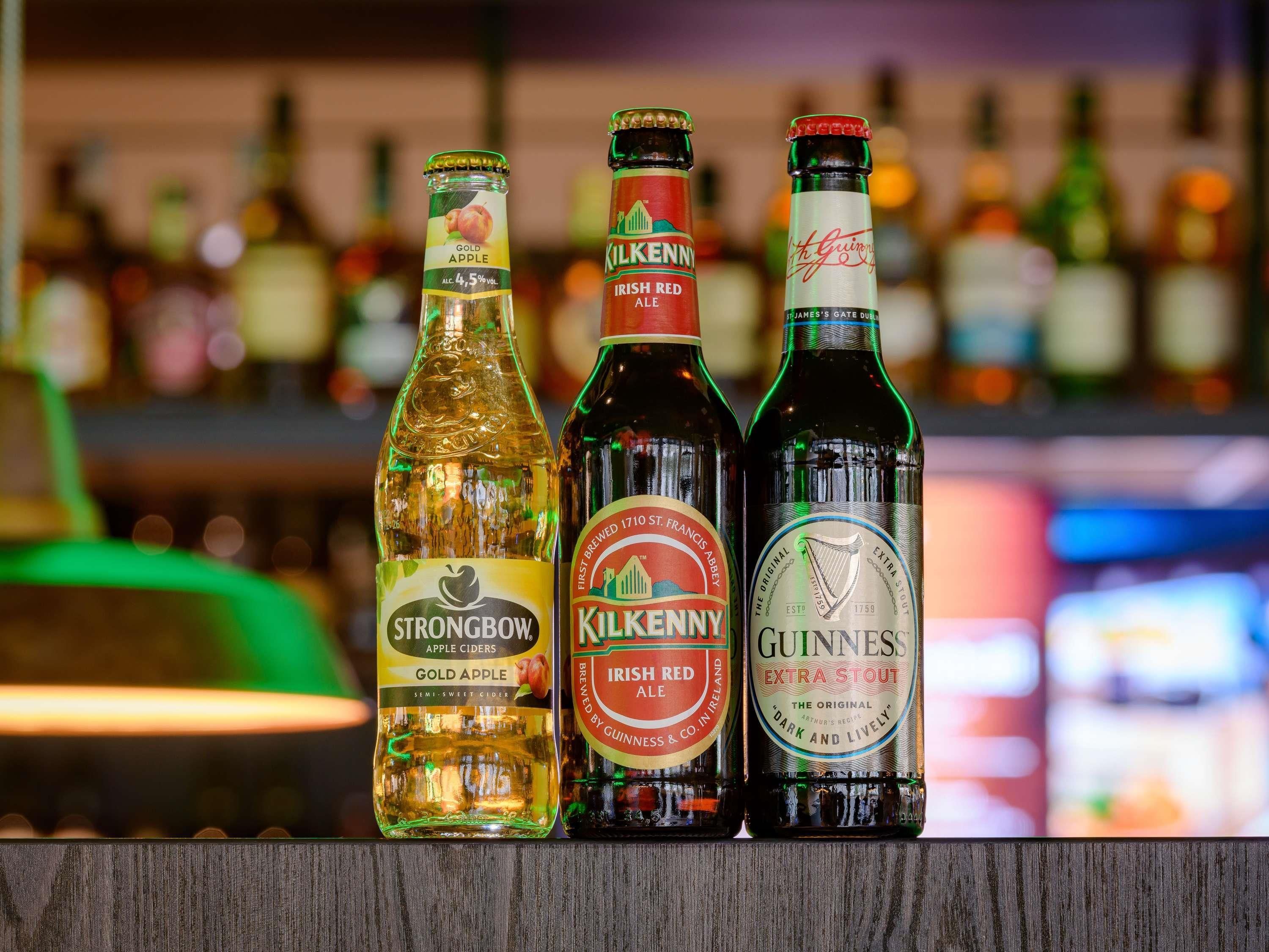 Three bottles of alcoholic beverages on a bar counter.