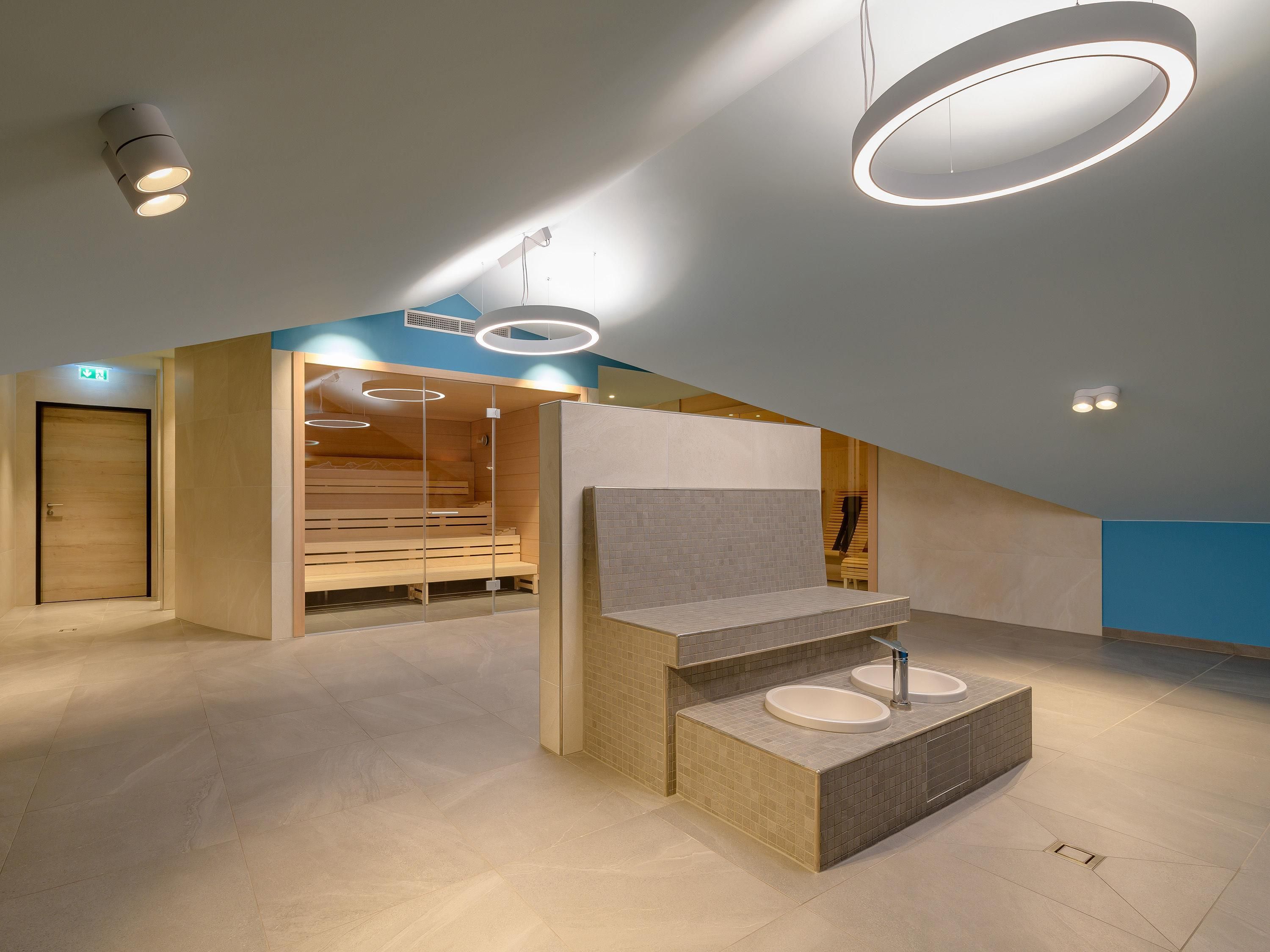 Un baño moderno con una bañera independiente, un tocador con lavamanos y una zona de ducha con banco.