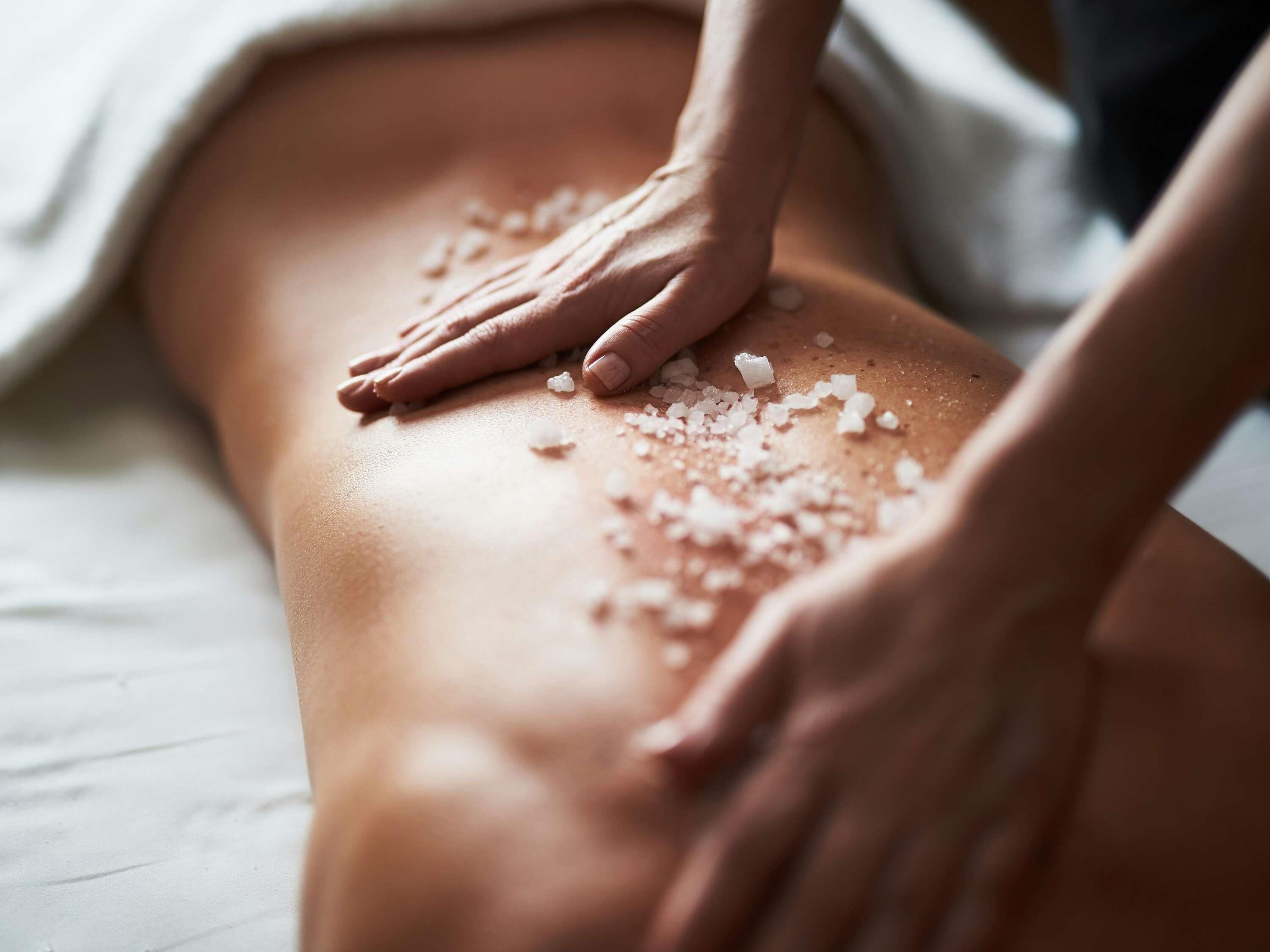 A massage with salt being applied to a person's back.