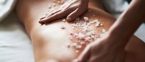 A massage with salt being applied to a person's back.
