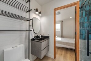 Ein modernes Badezimmer mit integriertem Waschbecken, einem Spiegel und einem Handtuchhalter.