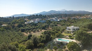 A residential area with modern houses, a swimming pool, and a mountainous backdrop. - Mithonies Villa, with Private Pool & BBQ, Walking distance to shops (Rethymno)