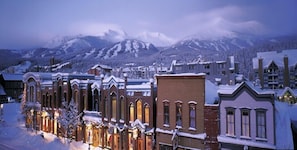 A snow-covered town with historic buildings and a mountain backdrop. - Four O'clock Lodge B05 (Breckenridge)