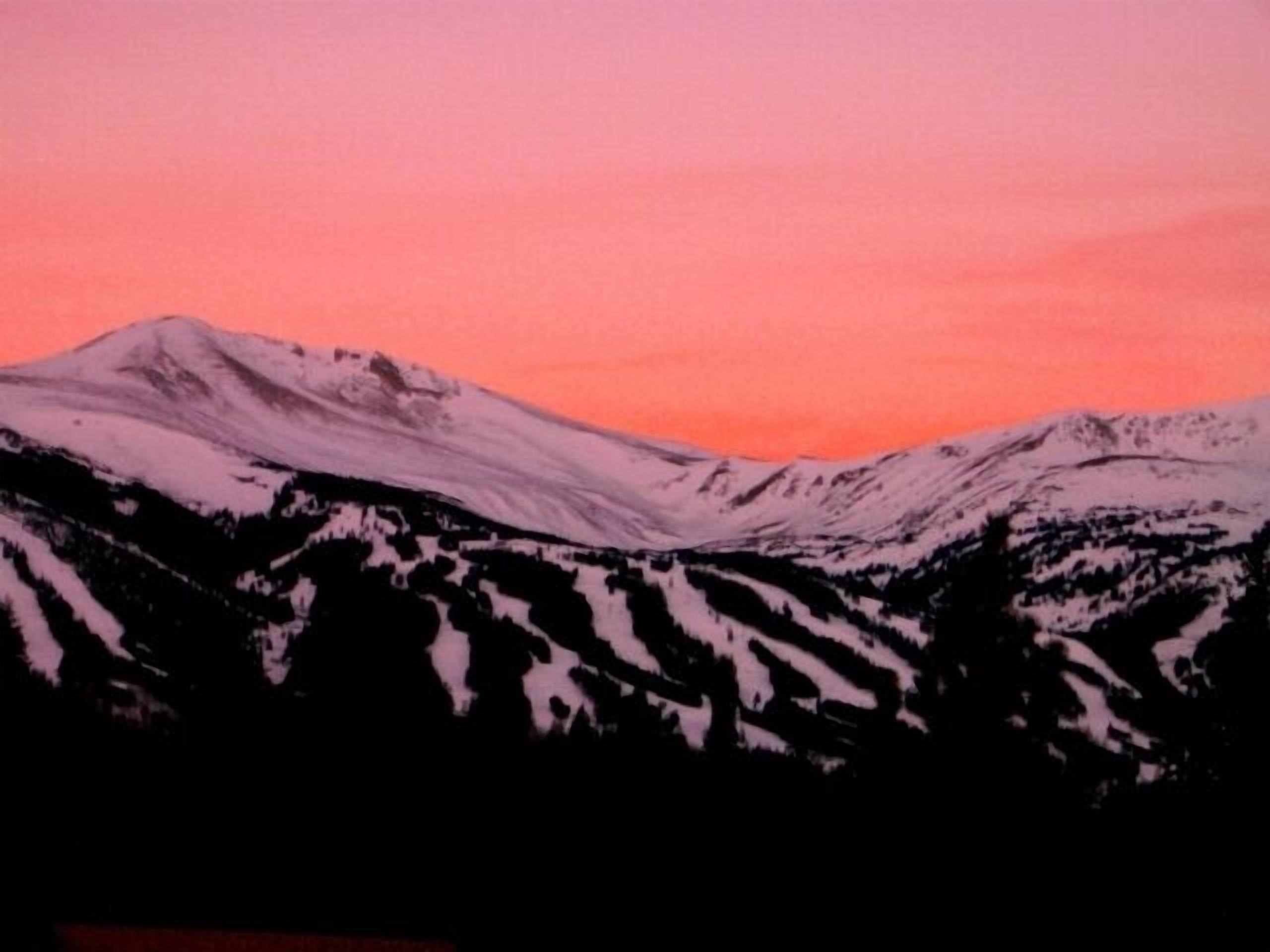 Une chaîne de montagnes aux sommets enneigés, sous un ciel rose.