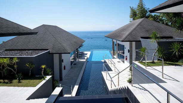 Un resort moderno con piscina y vista al océano.