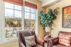 Relax in this inviting living room with a comfortable armchair, side table, and beautiful view of the surrounding mountains.